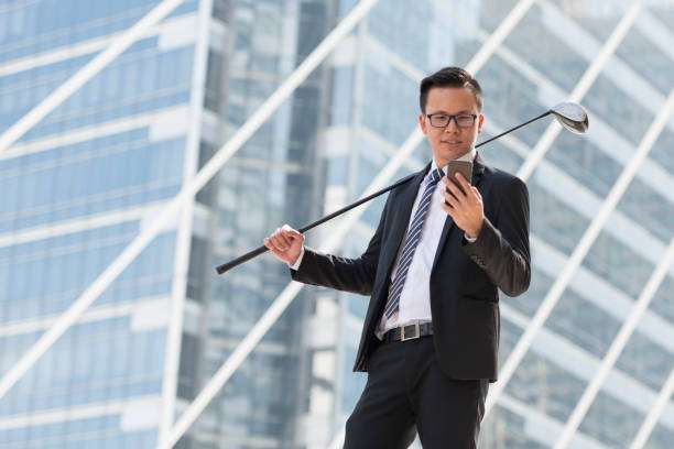 A businessman with a golf club in hand, planning his next round for his golf bag.