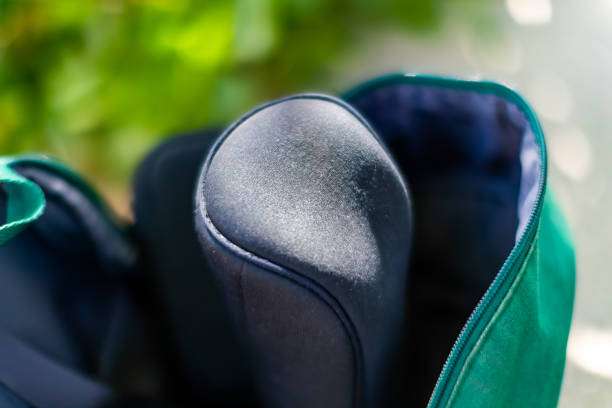 Close-up view inside a green golf bag, showing protective club head covers.